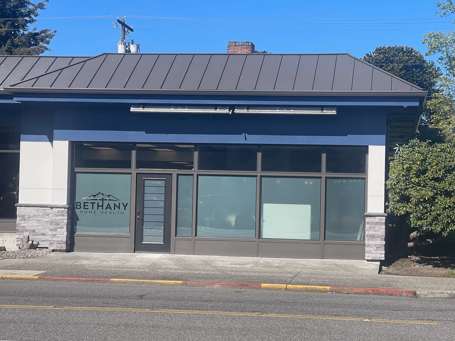 Exterior view of a blue building with large windows and Bethany Home Health signage.