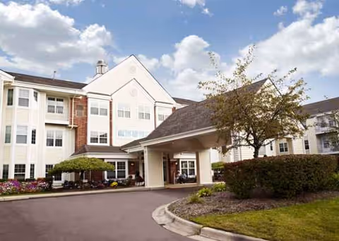 Exterior of Baldwin House Hazel Park Senior Living, with covered entrance and landscaped grounds.