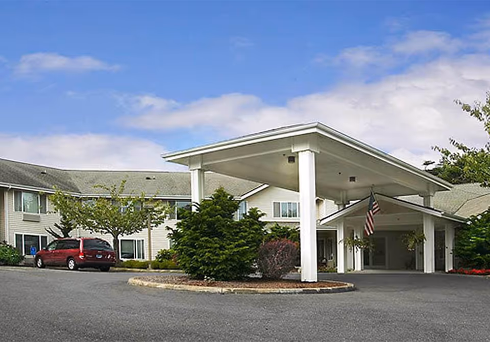Exterior view of Broadway Home's front entrance with a canopy and American flag
