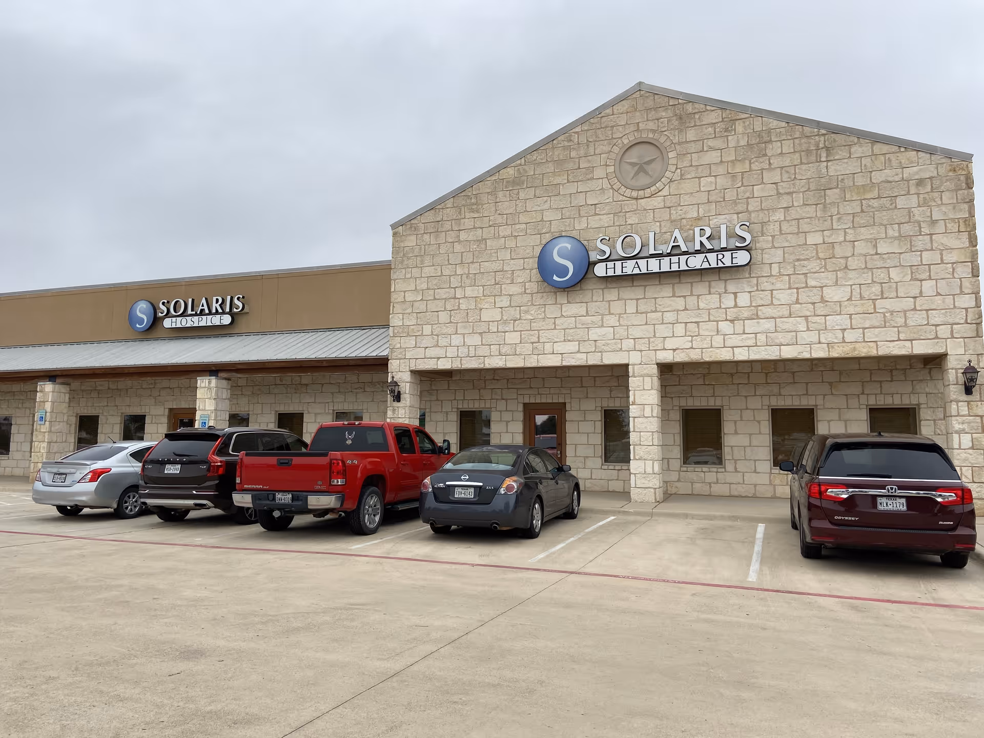Exterior view of Solaris Healthcare building with parked cars in front.