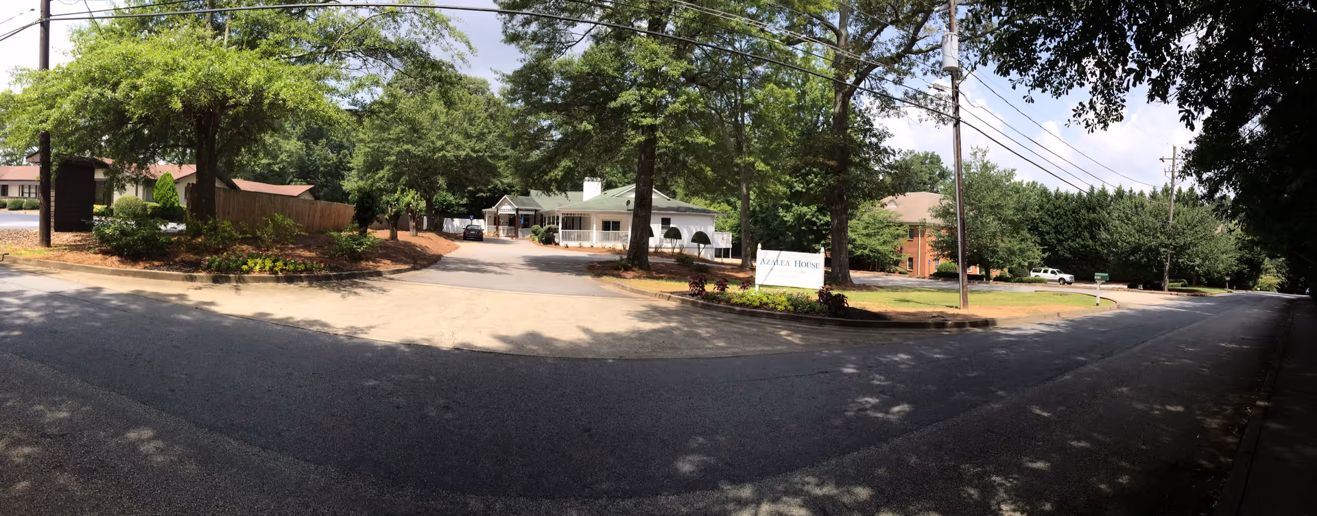 Wide view of Serenity Empire at Decatur entrance with trees, sign, and circular driveway.