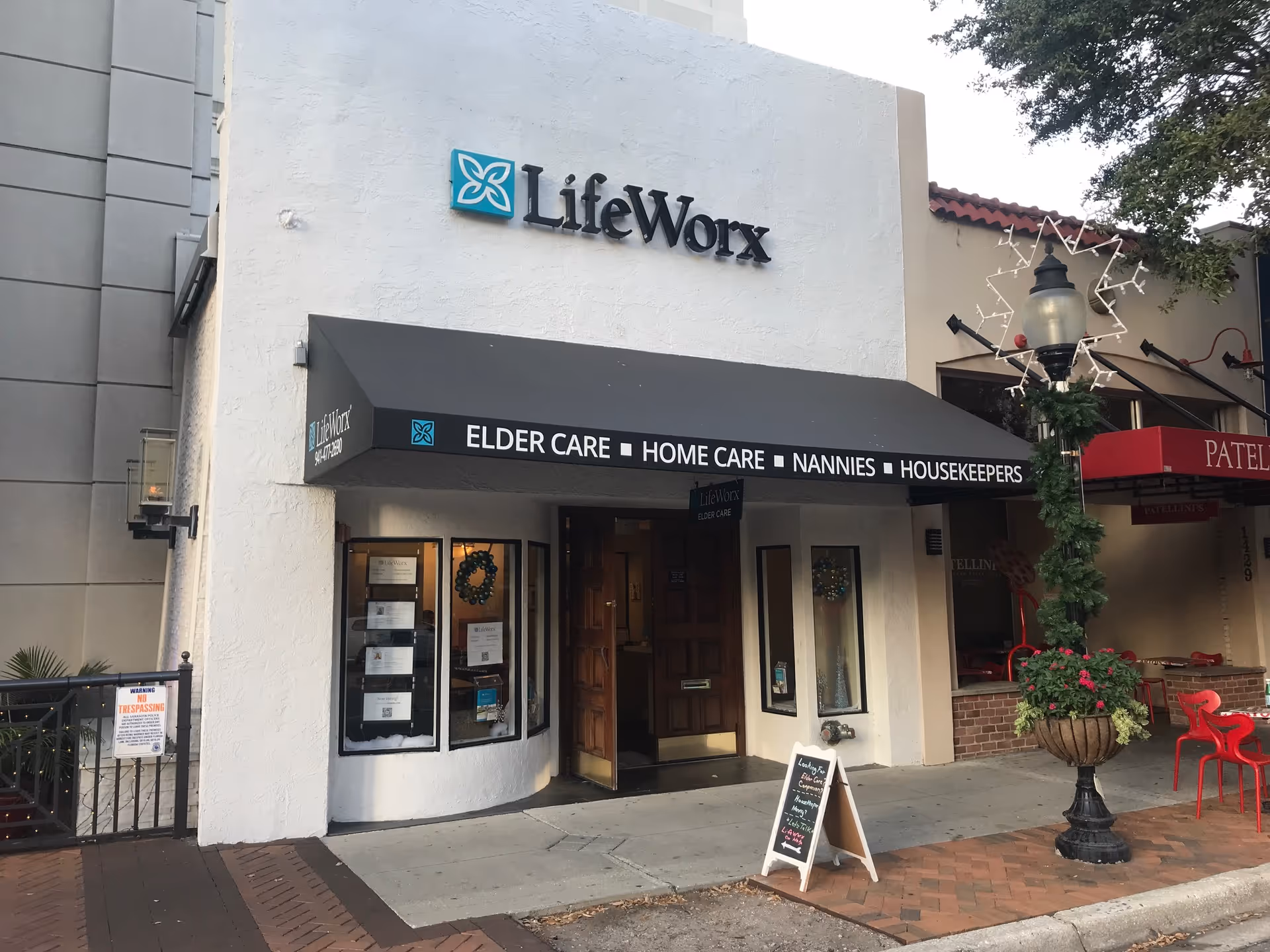 Exterior LifeWorx elder care building with black awning and glass entry doors.