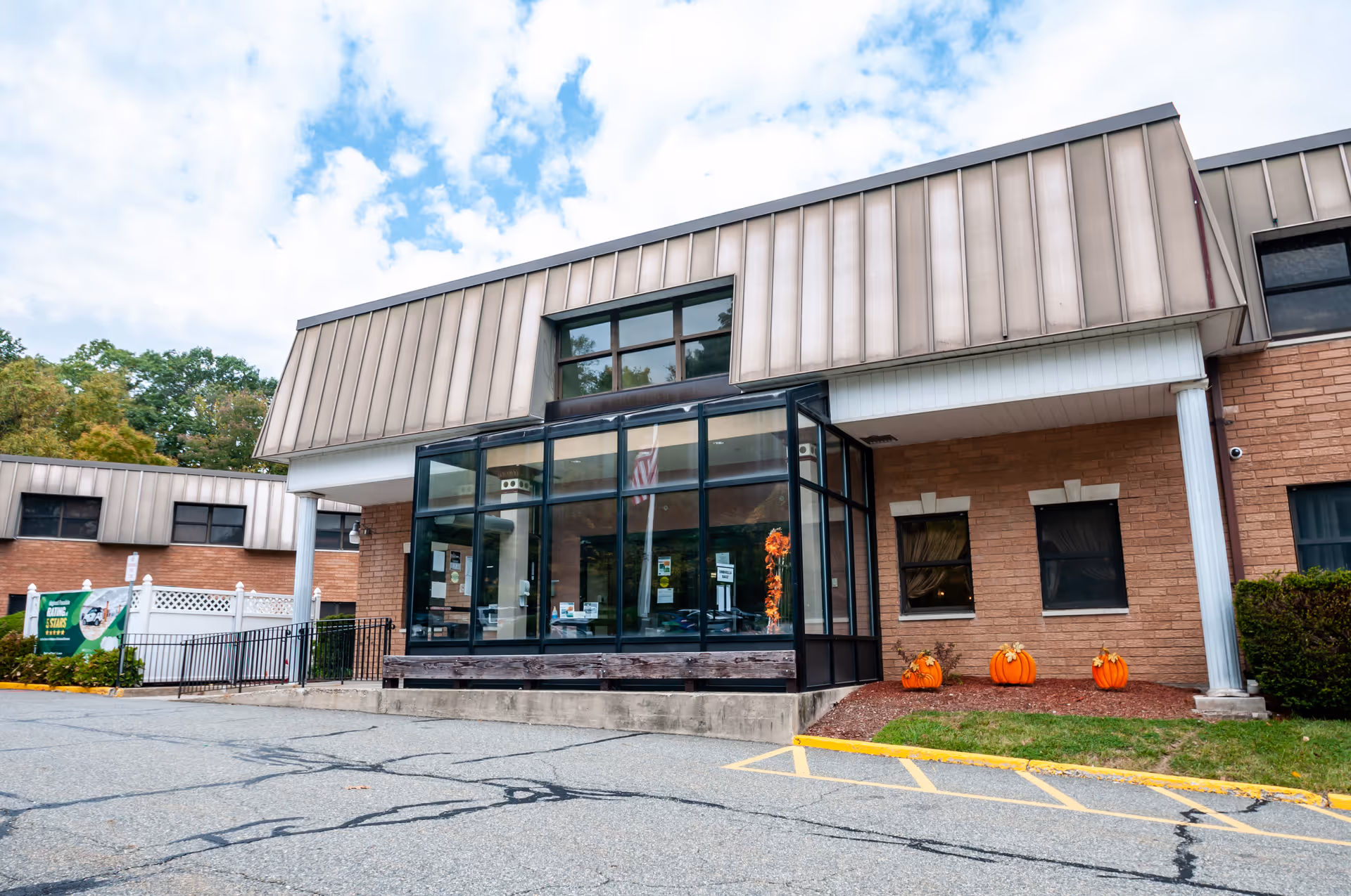 Front view of Oakland Rehabilitation & Healthcare Center with glass entry and pumpkins.