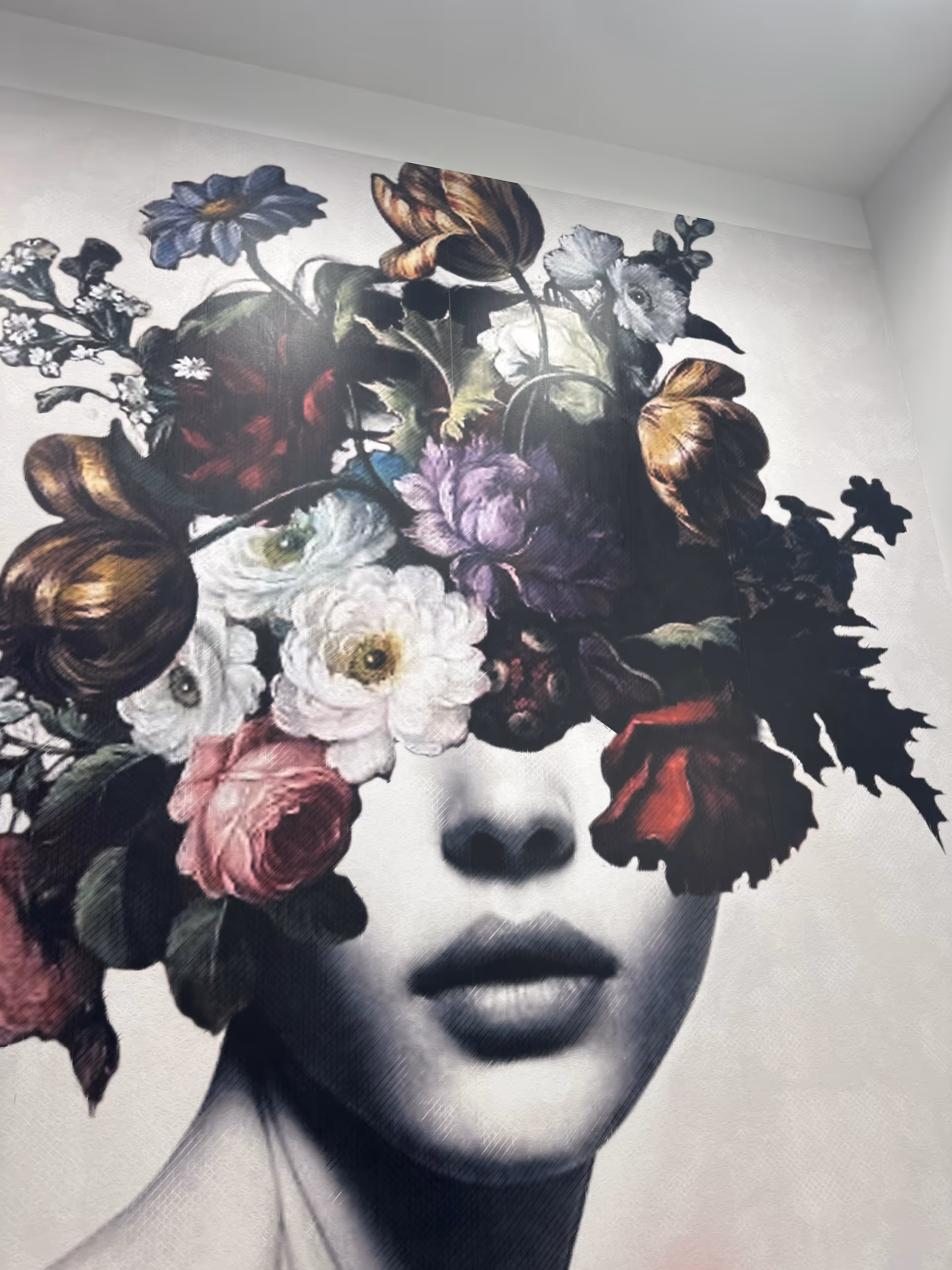 Black-and-white portrait of a woman's face with vibrant flowers obscuring her eyes.