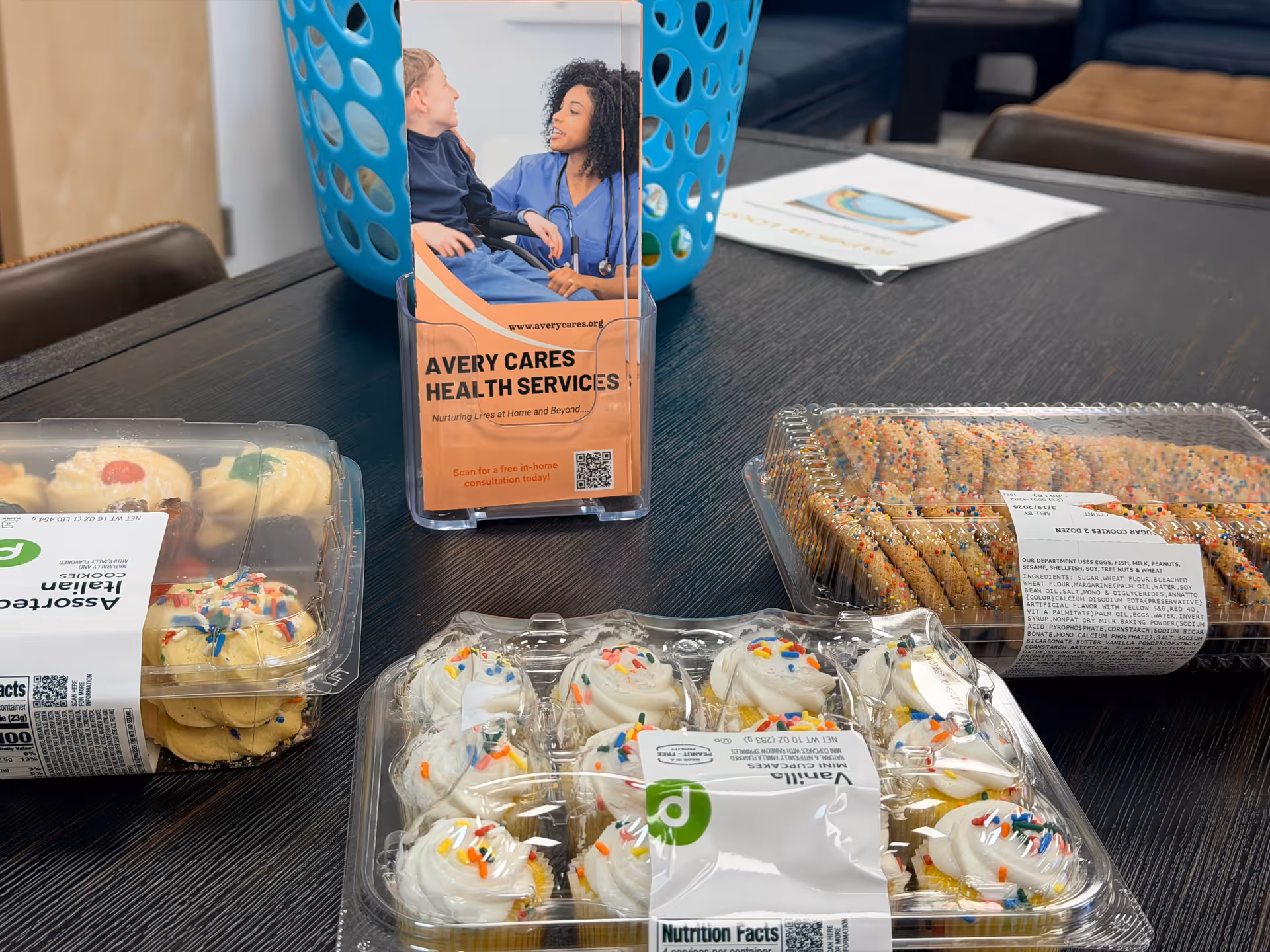 Assorted pastries on a dark table with Avery Cares Health Services brochure.