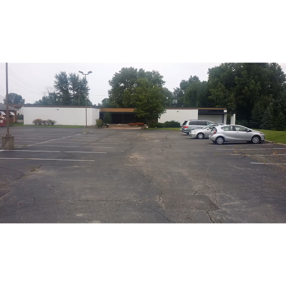 Exterior view of Nina's Health Care Services facility with a parking lot and cars.