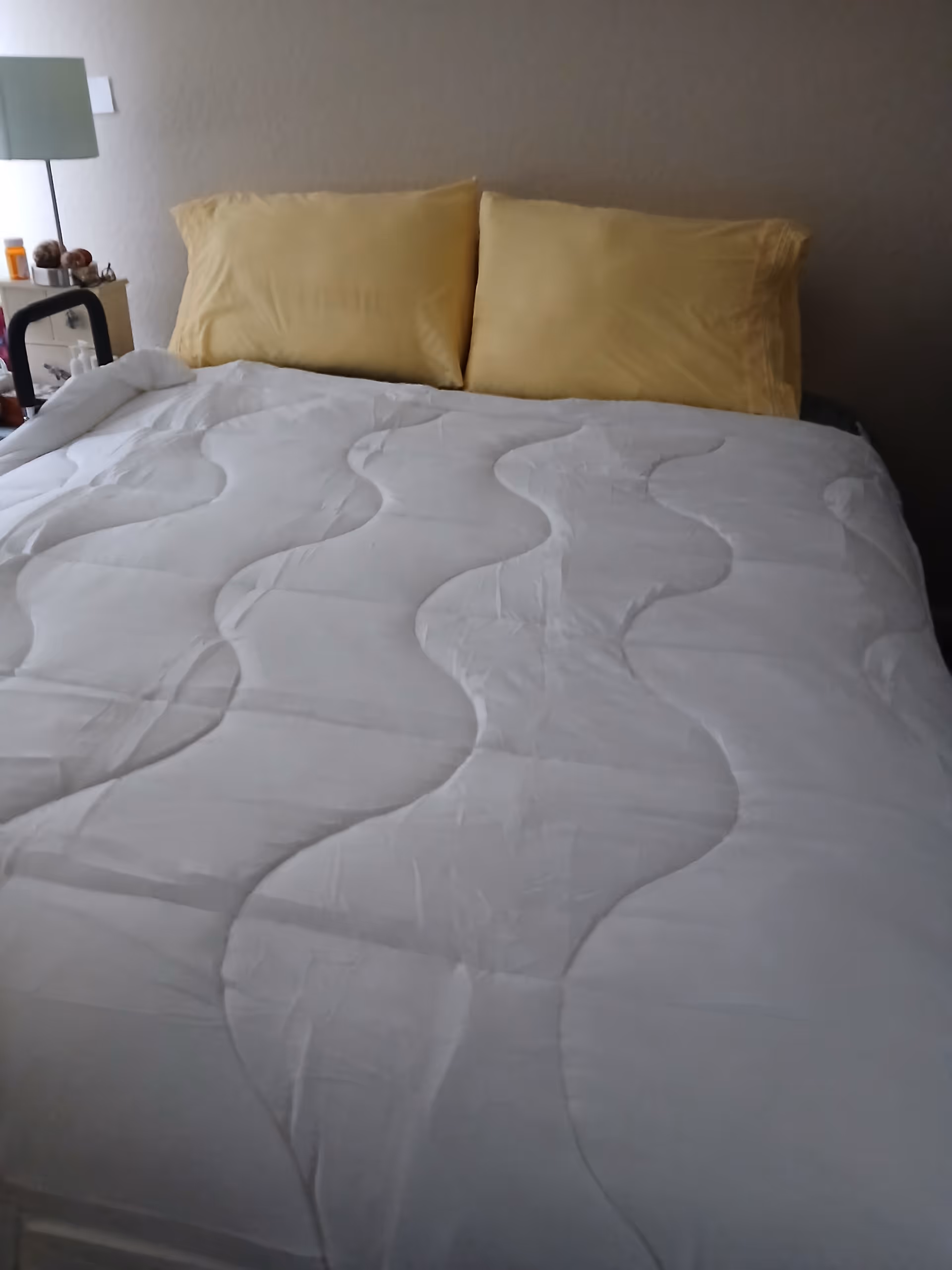 A neatly made bed with yellow pillows in a cozy bedroom