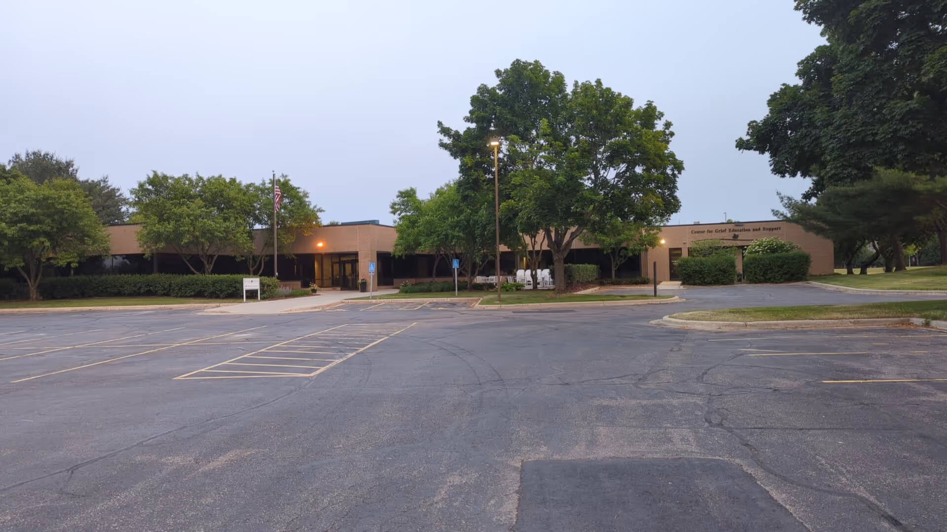 Exterior view of the Seasons Hospice facility with a parking lot and trees.