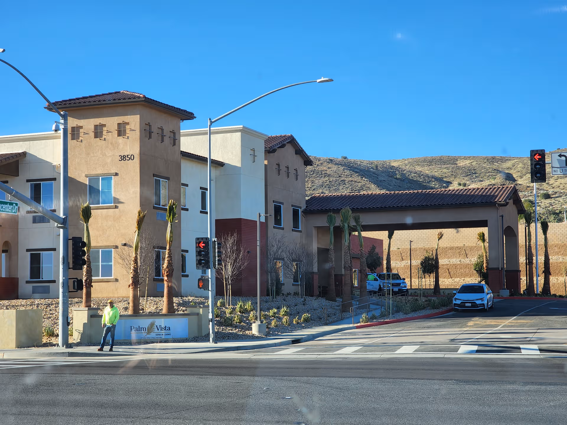 Exterior view of Palm Vista Senior Living building along a street with a crosswalk