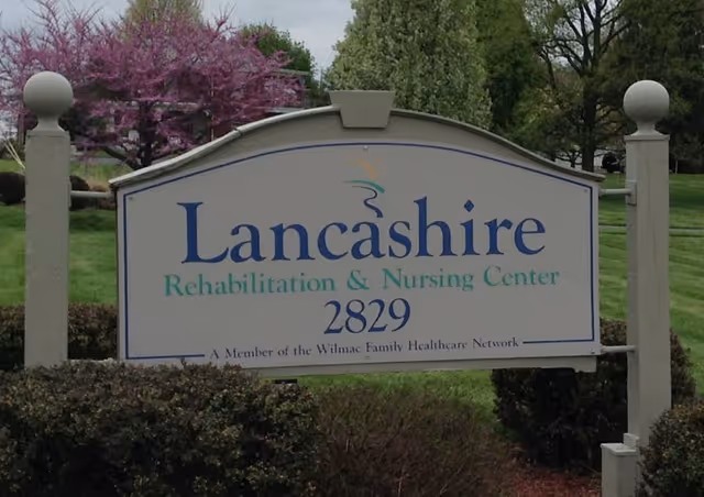 Lancashire Rehabilitation and Nursing Center sign displayed on a landscaped grassy area.