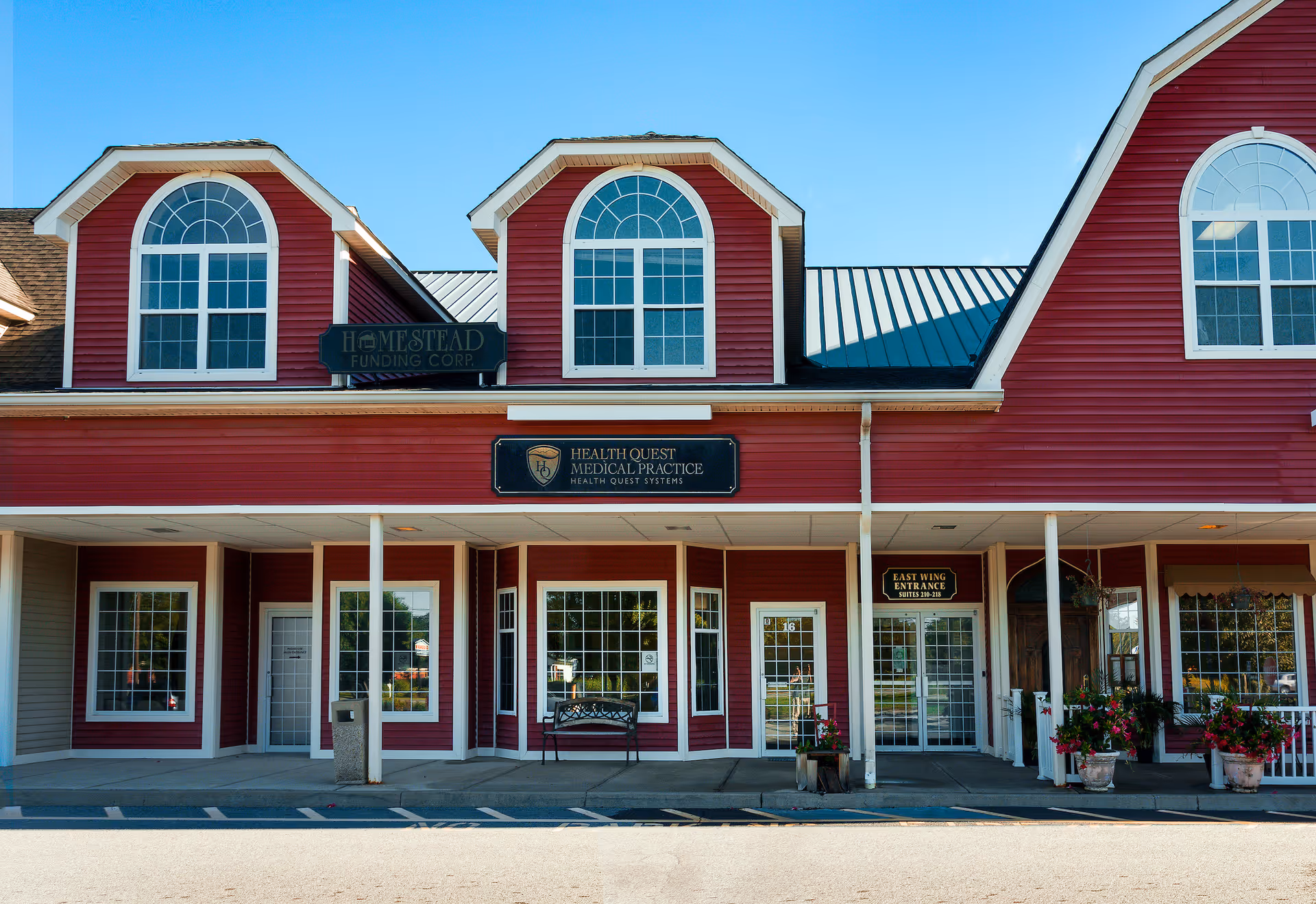 Exterior view of a red medical practice building with storefront entrances.
