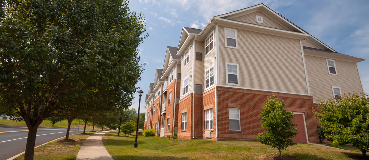 Exterior view of Chapline House senior living facility with brick base and beige siding