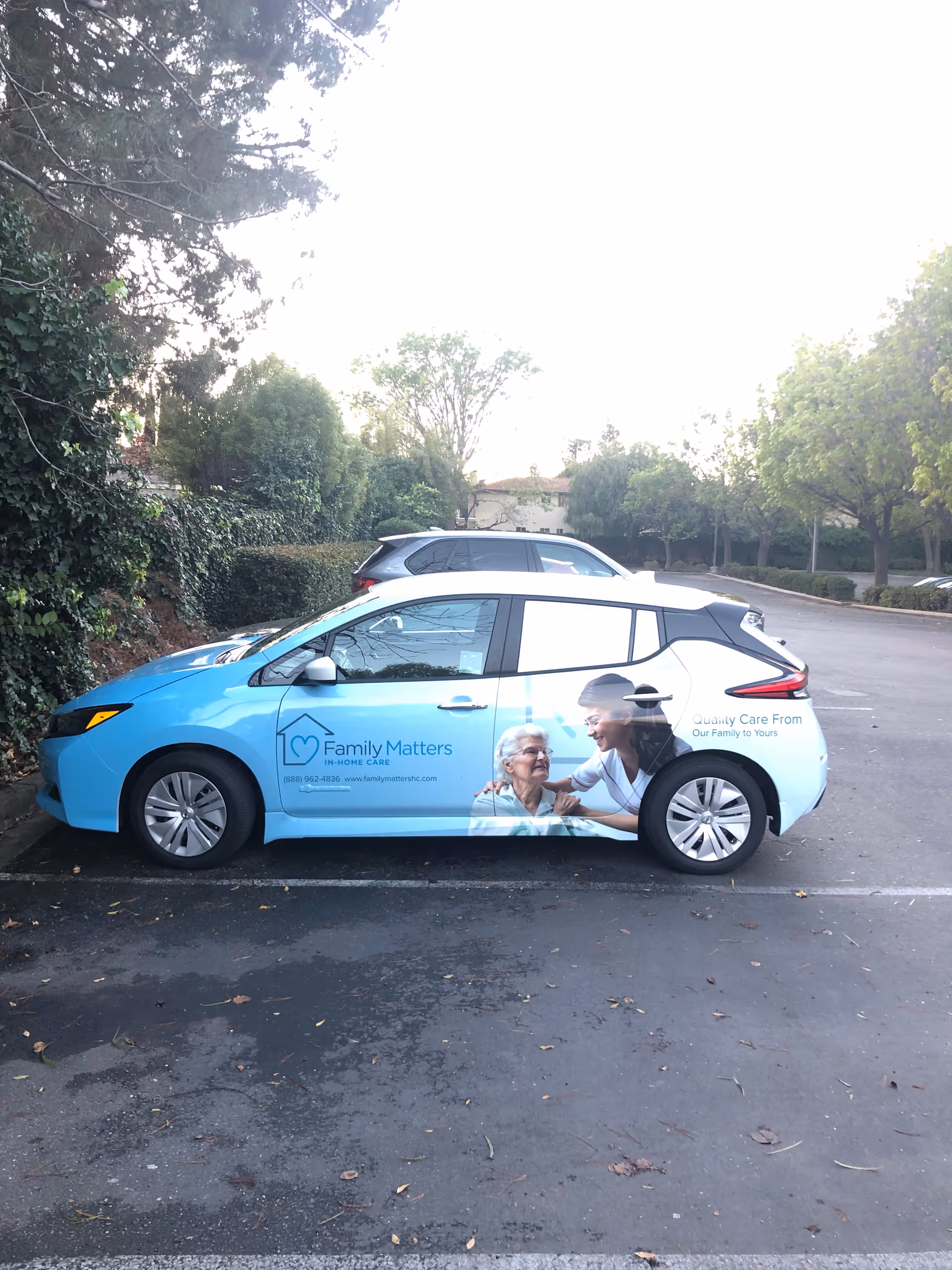 Blue van with Family Matters in-Home Care wrap parked in a parking lot.