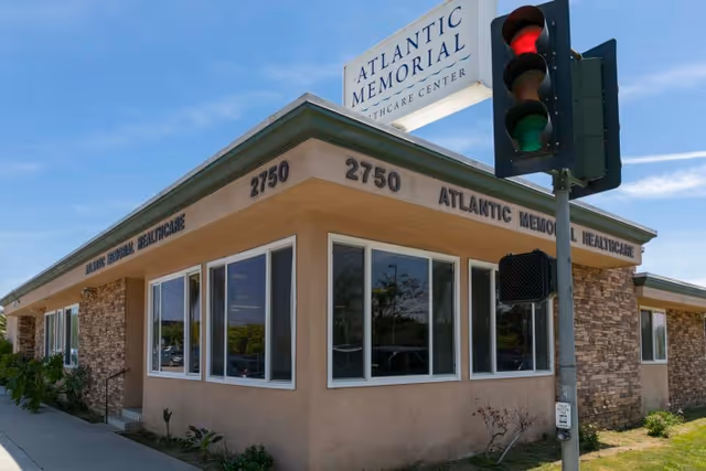 Corner view of the Atlantic Memorial Healthcare Center building with address numbers 2750 and a traffic light in the foreground.