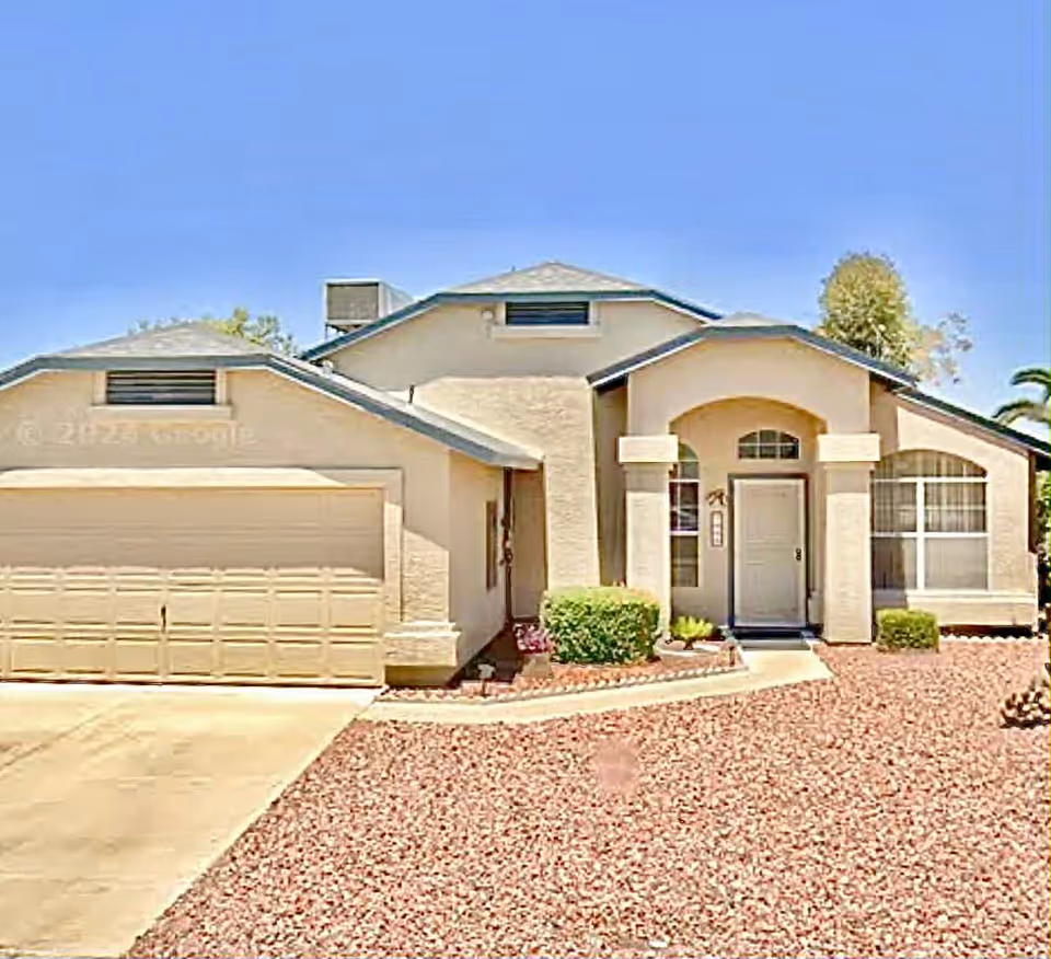 A single-story beige assisted living facility front entrance with a two-car garage.