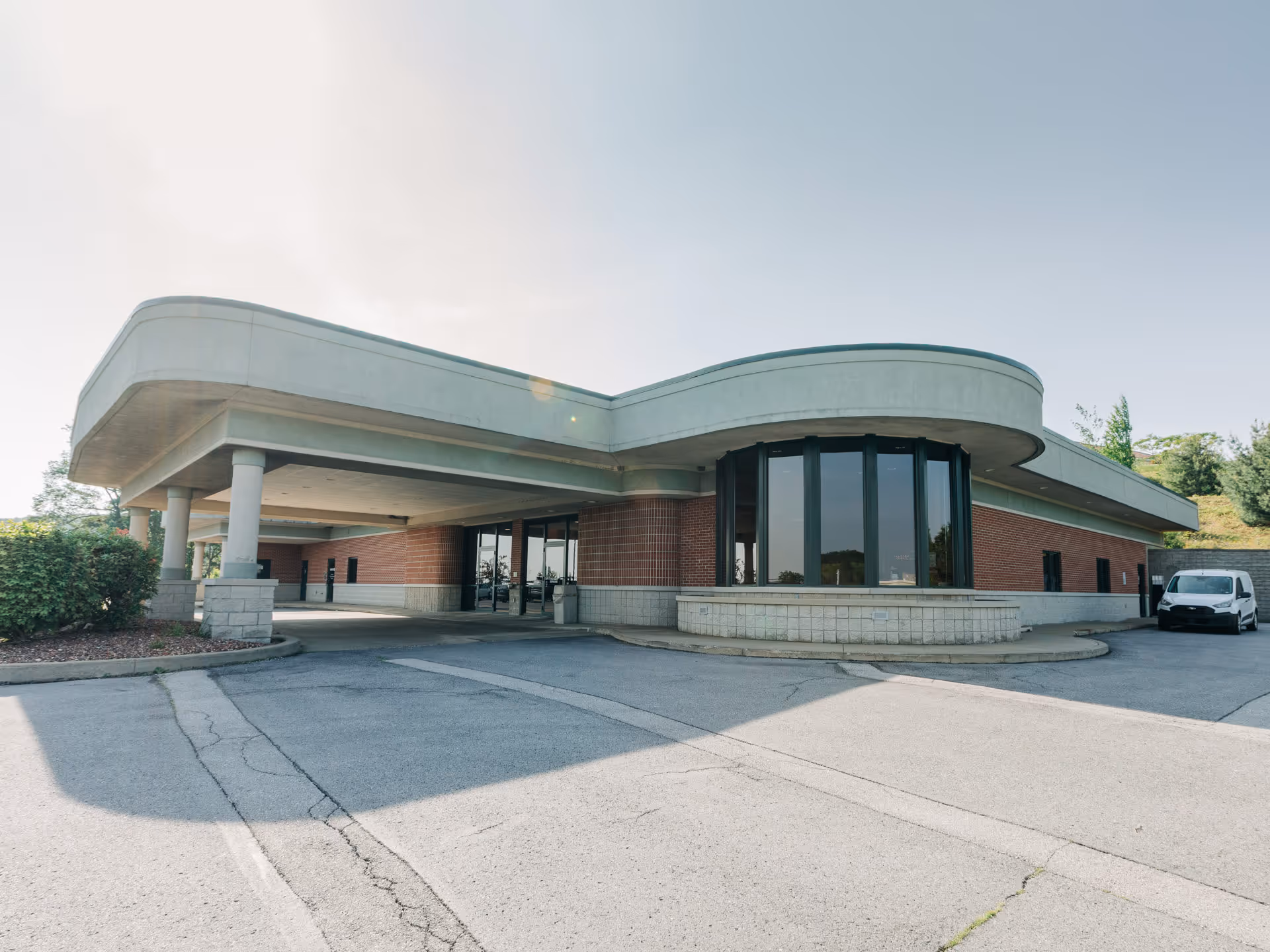 Exterior view of SMP Home Medical facility with curved entrance and a parked van.