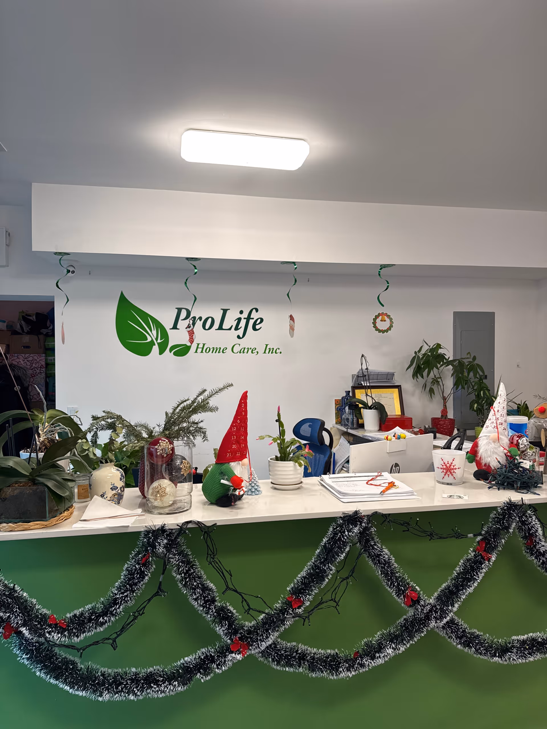 Reception desk inside a facility with ProLife Home Care sign and festive decorations.