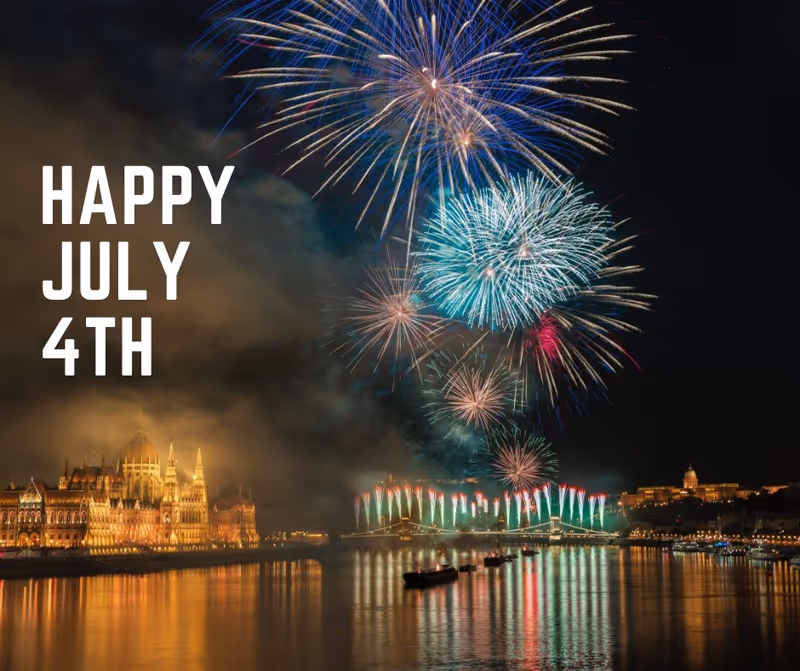 Colorful fireworks light a riverfront city at night with July 4th text.