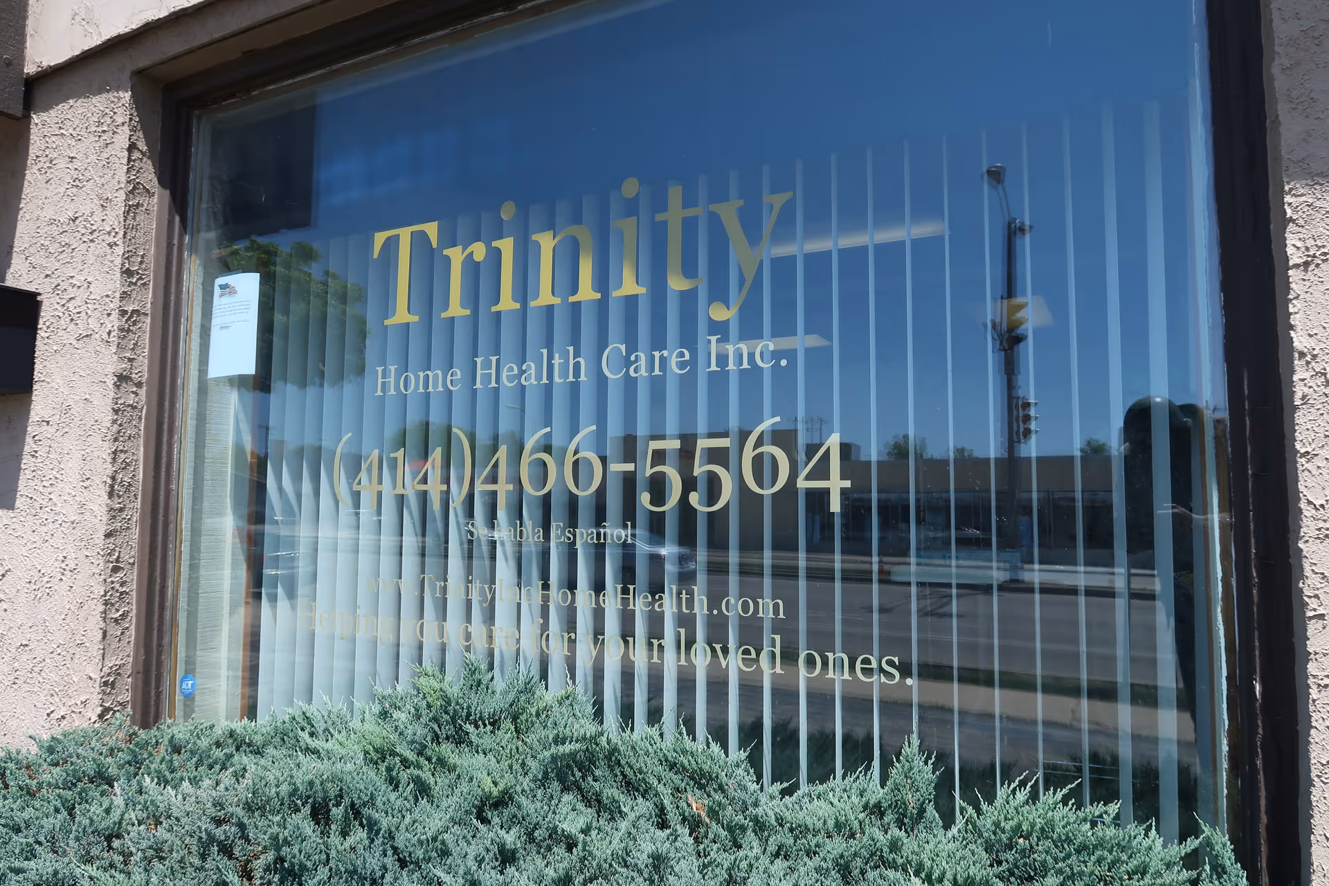 Exterior window displays Trinity Home Health Care Inc. with blinds and reflections.
