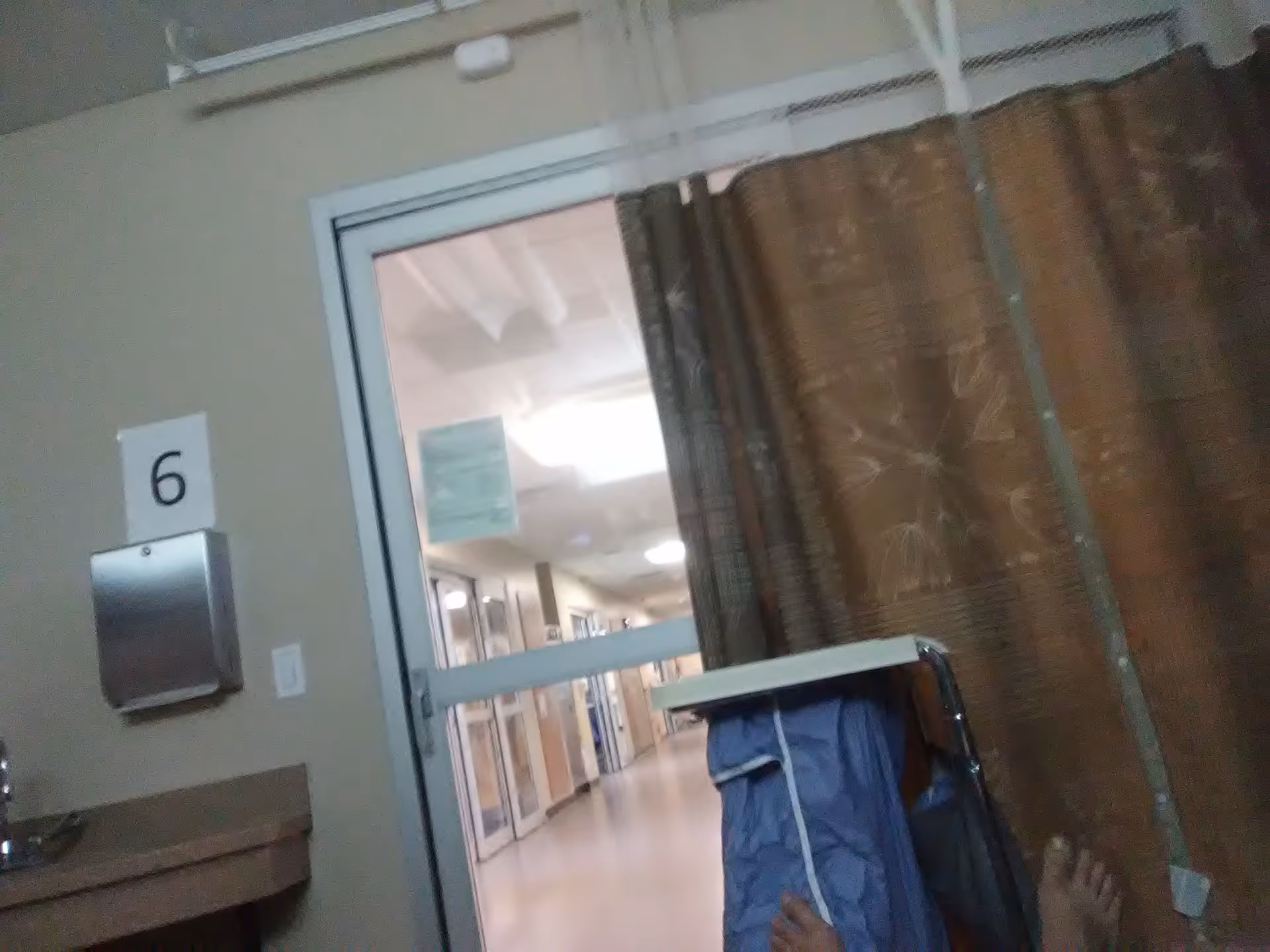 Indoor senior living hallway with a movable cart and curtained room partitions.