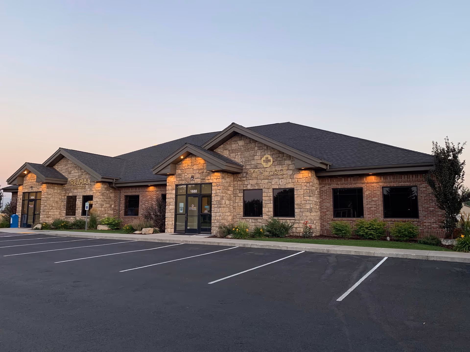 Front exterior of OneSource Home Health and Hospice building with a parking lot.