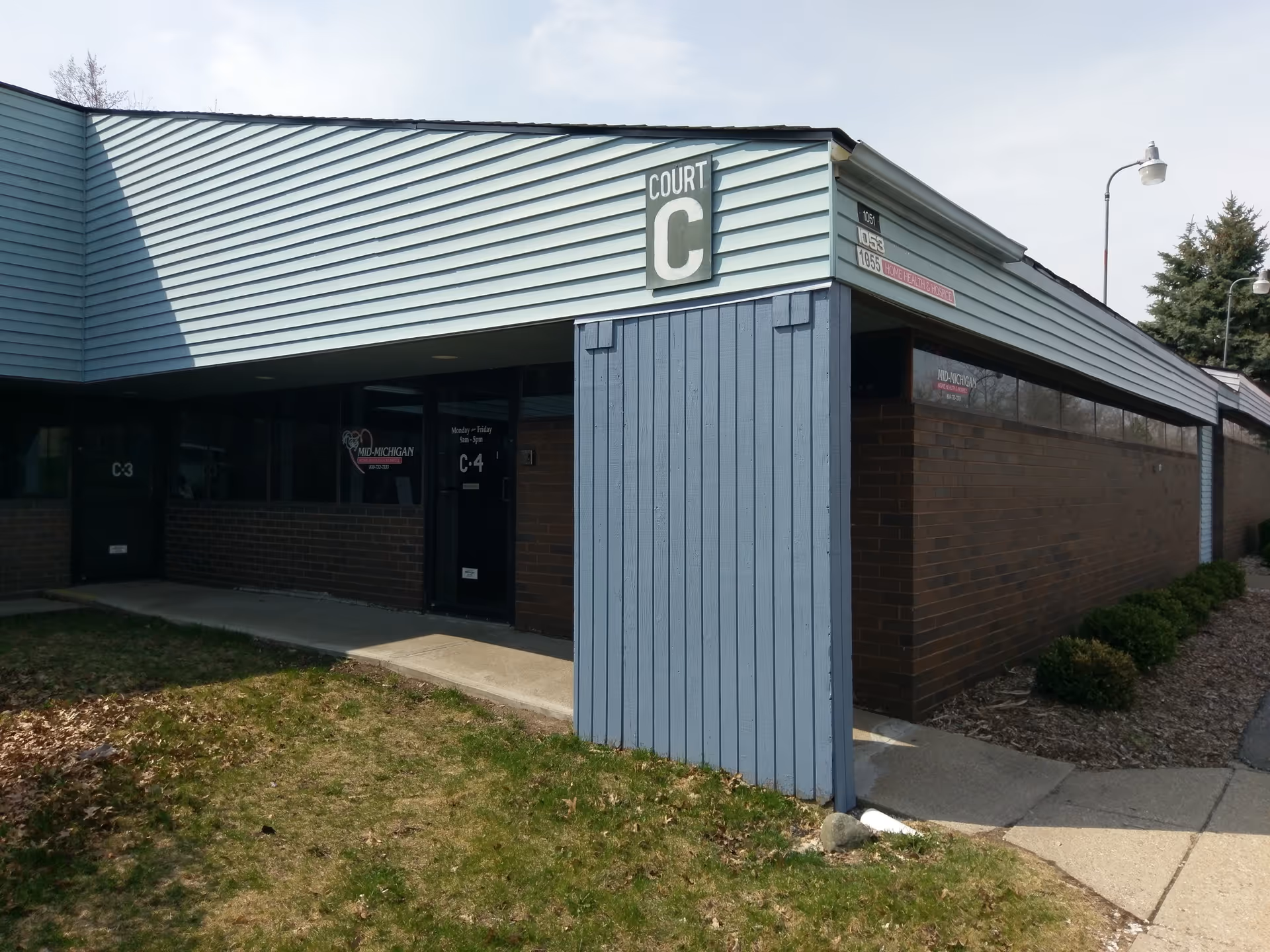 Exterior view of a blue-brick facility with a Court C entrance sign.