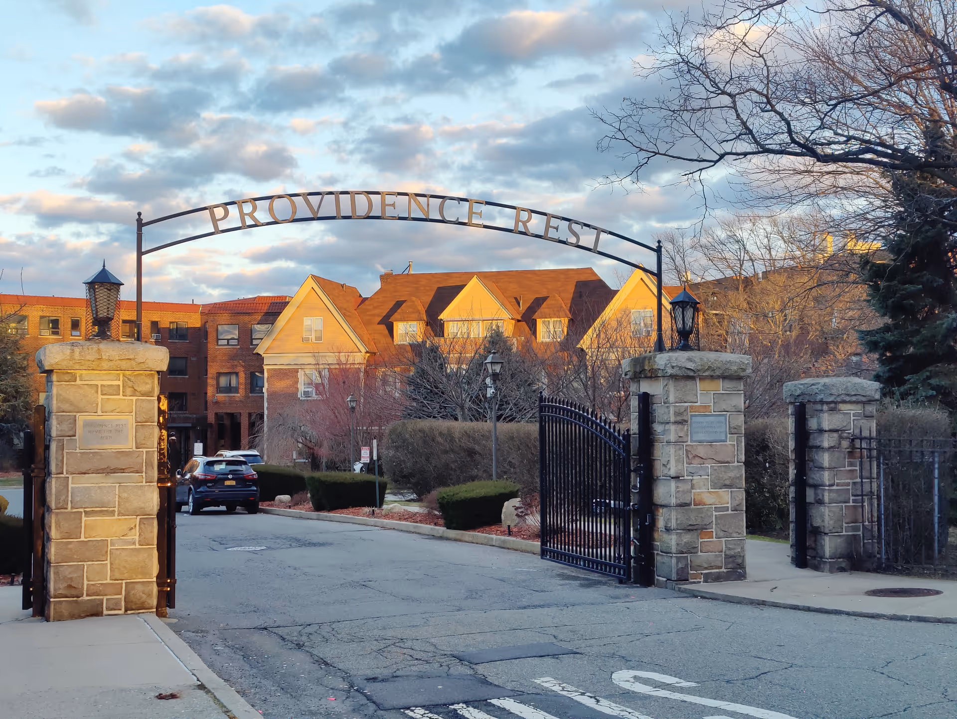 Exterior view of Providence Rest entrance with arched gate and brick buildings.