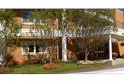 Brick Milford Health Care Center exterior with entrance porch and surrounding trees.