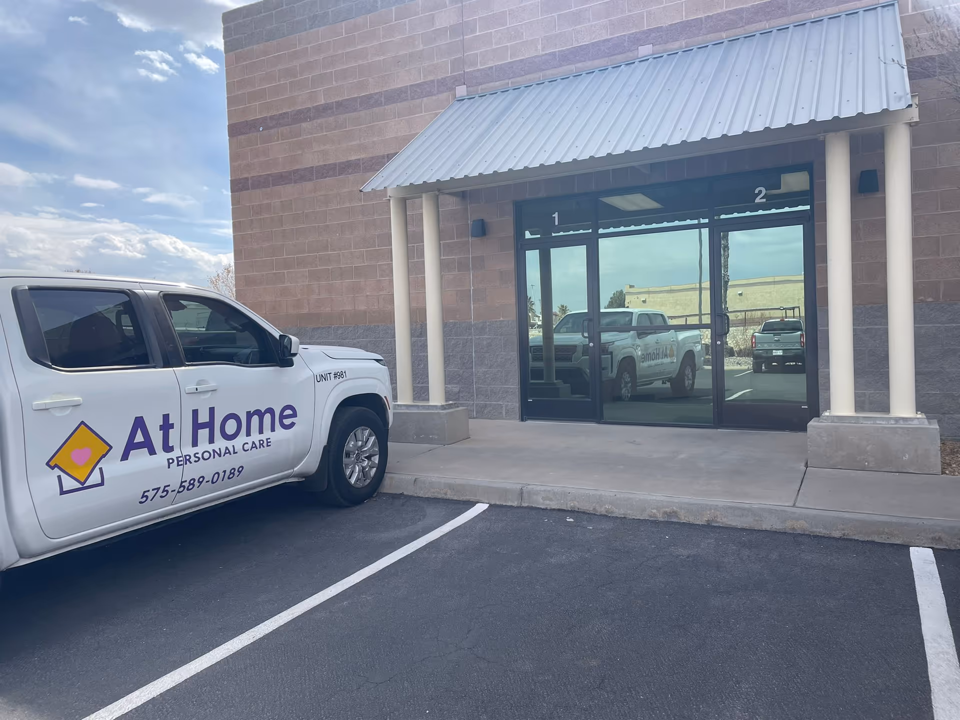 Exterior view of the facility entrance with a branded At Home Personal Care truck.