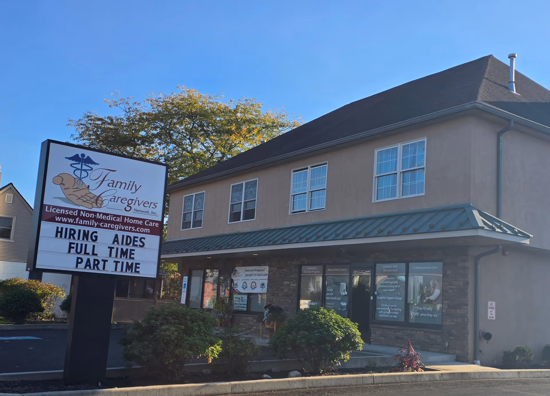 Two-story beige building featuring a large Family Caregivers Network sign at the front.