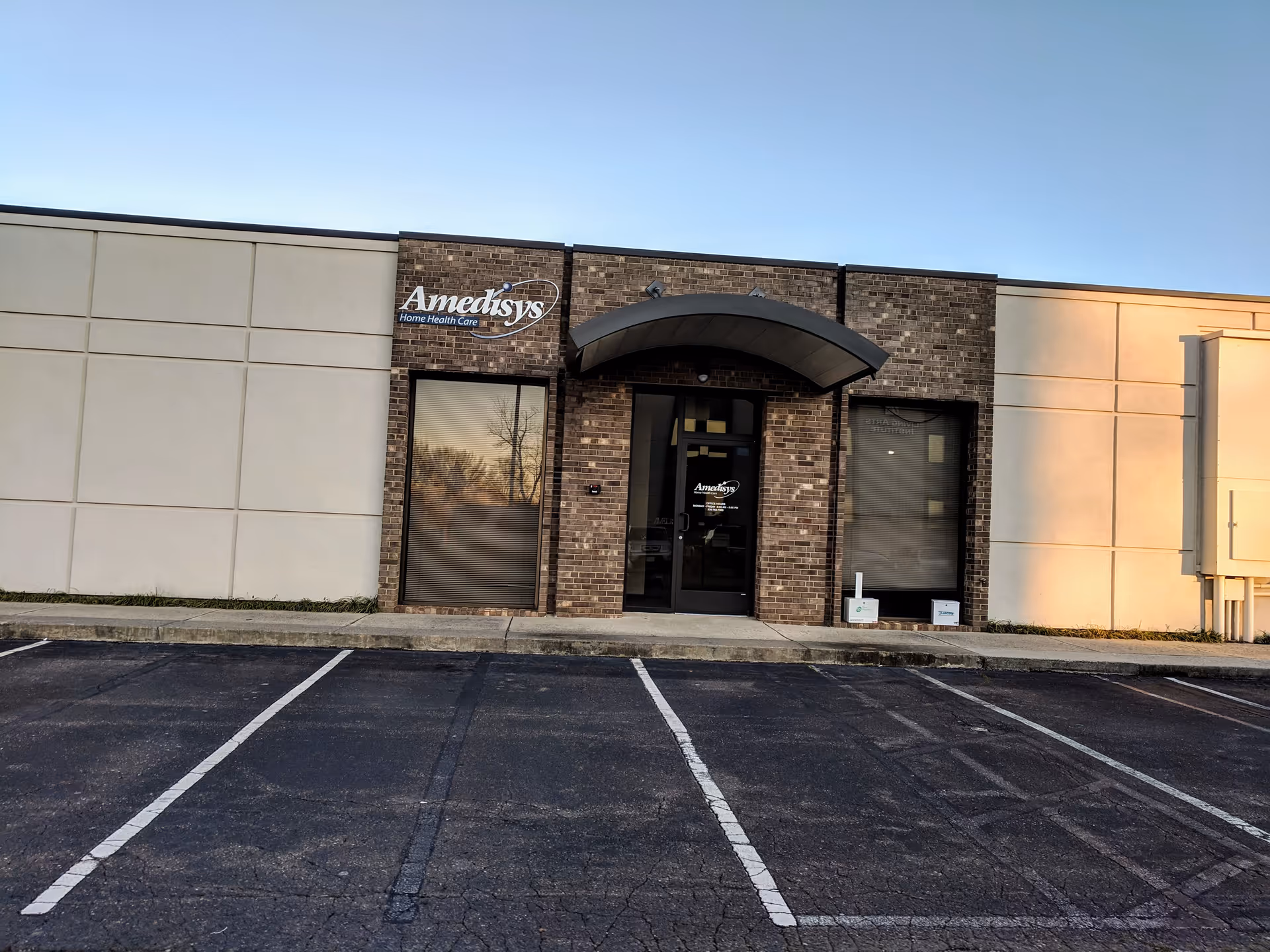 Building front of Amedisys Home Health Care with brick facade and parking lot.