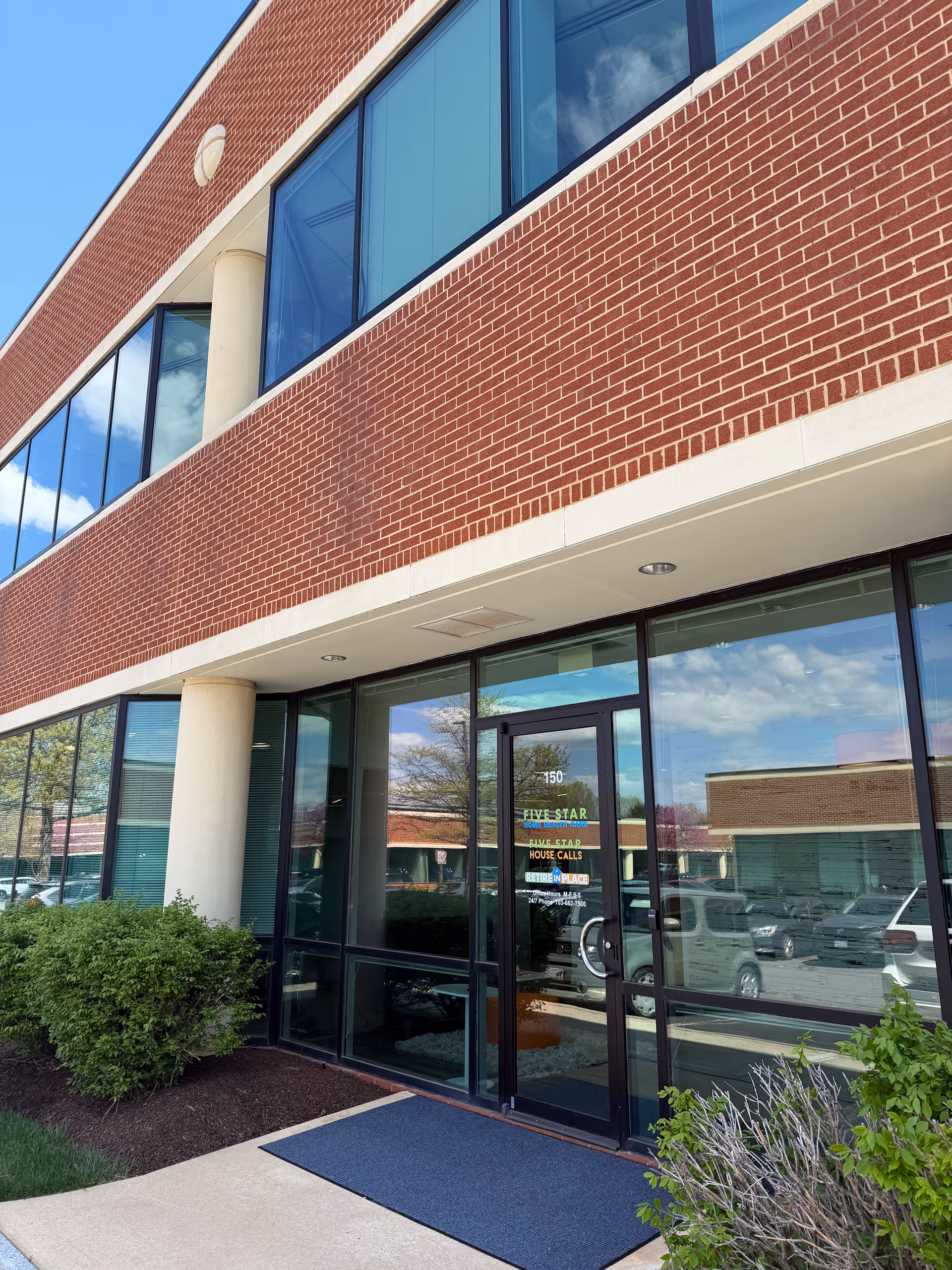 Front entrance of Five Star Home Health Care building with brick exterior and glass doors.
