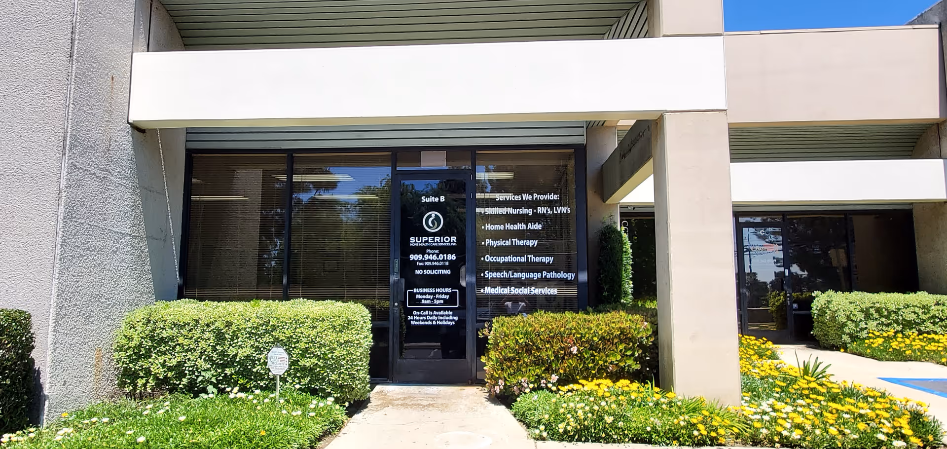 Front view of Superior Home Health Care building entrance with glass doors and shrubs.