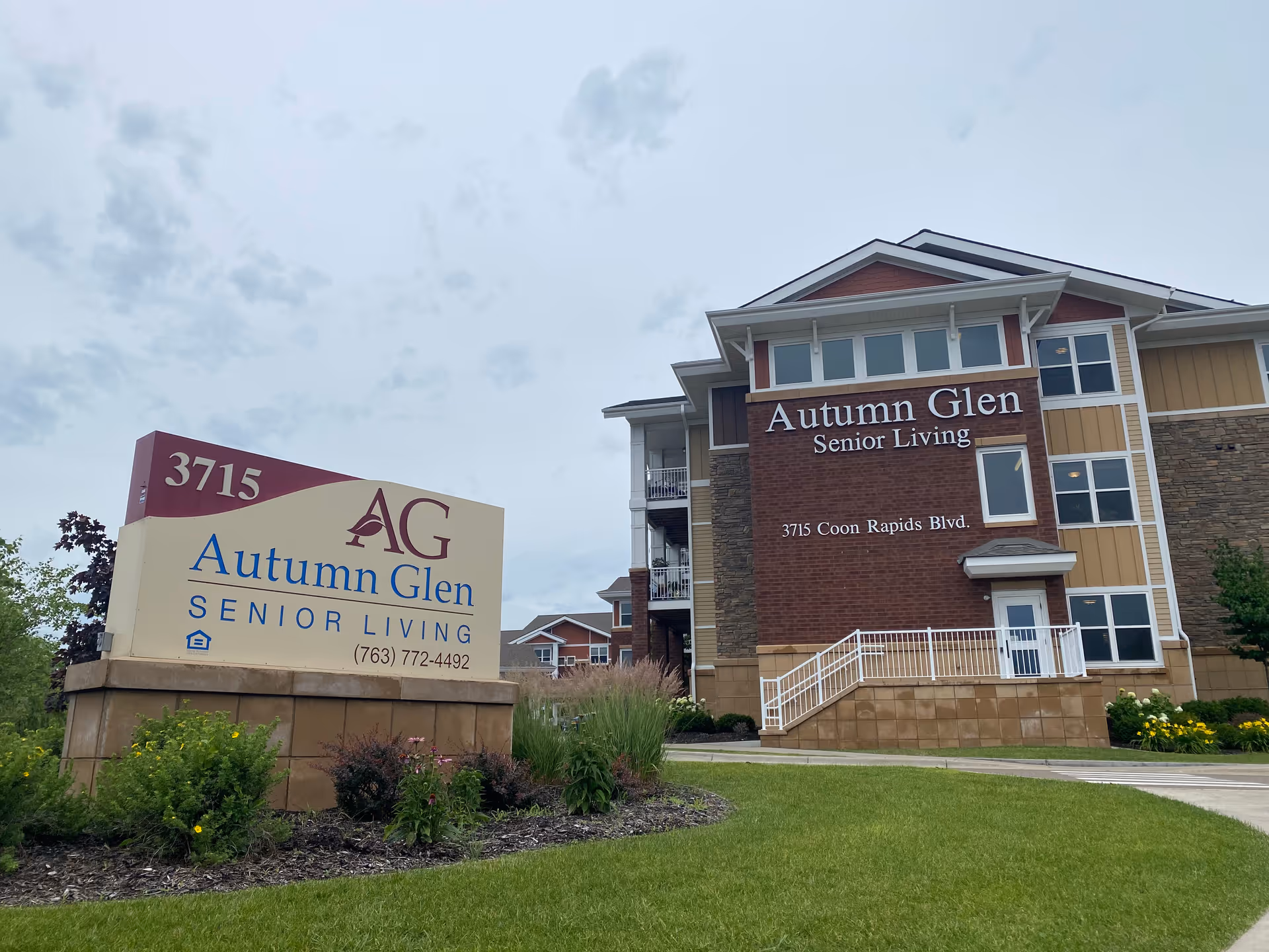 Exterior view of Autumn Glen Senior Living building with front sign and landscaping.
