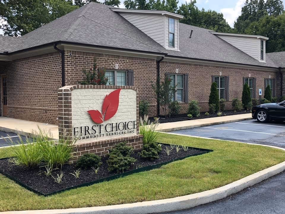 Exterior view of a brick facility with a First Choice Community Services sign.