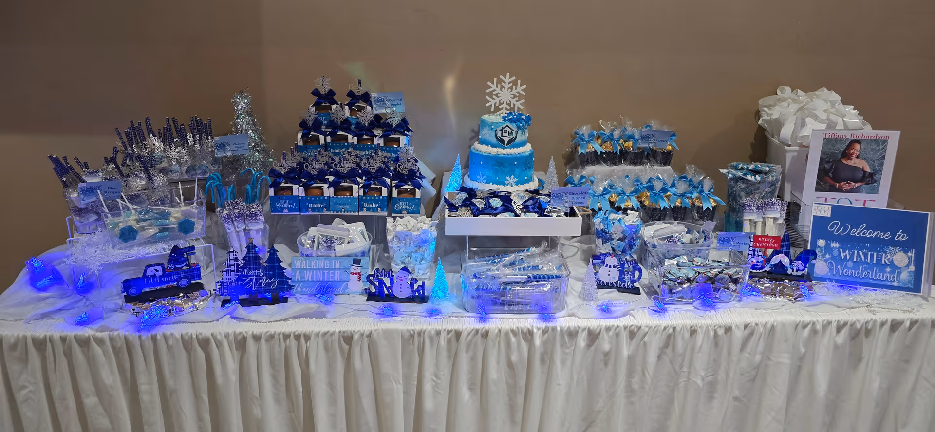 Blue winter-themed dessert table display at Helping Hands Home Management LLC indoors.
