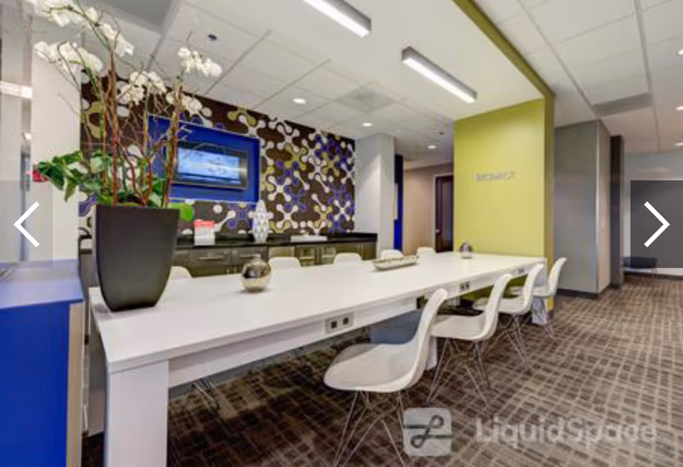 Bright reception area with a long white counter, modern chairs, decorative wall