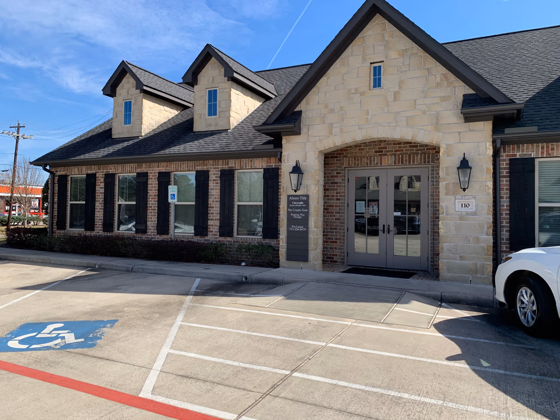 Exterior view of Chrysalis Home Healthcare building with brick/stone facade, accessible entrance, and parking lot.