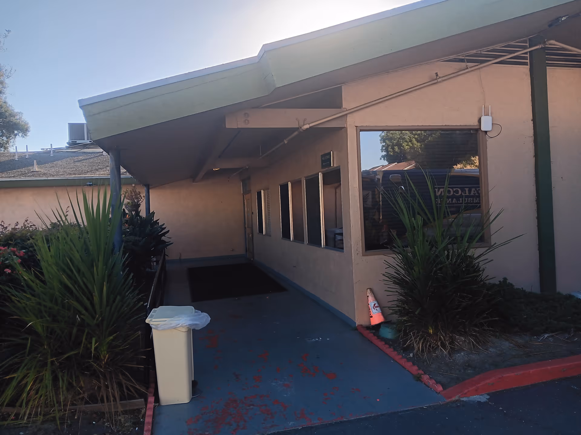Exterior view of Baypoint Healthcare Center with walkway, windows, and landscaping.