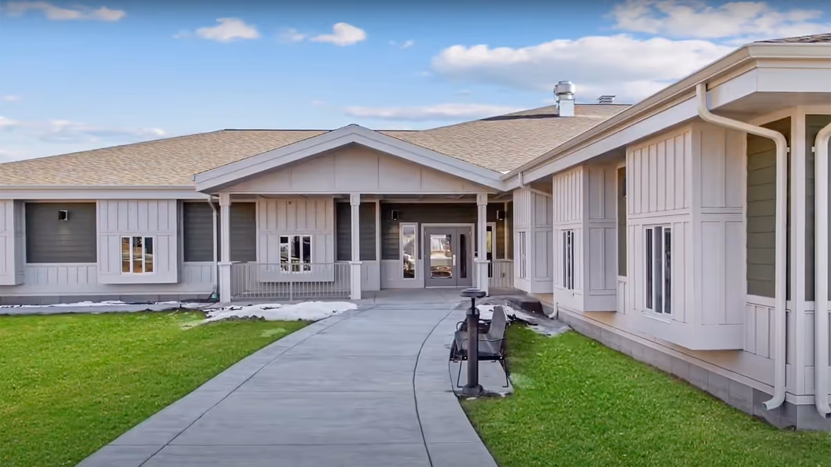 Exterior of a single-story veterans home with a curved walkway to a covered entrance.