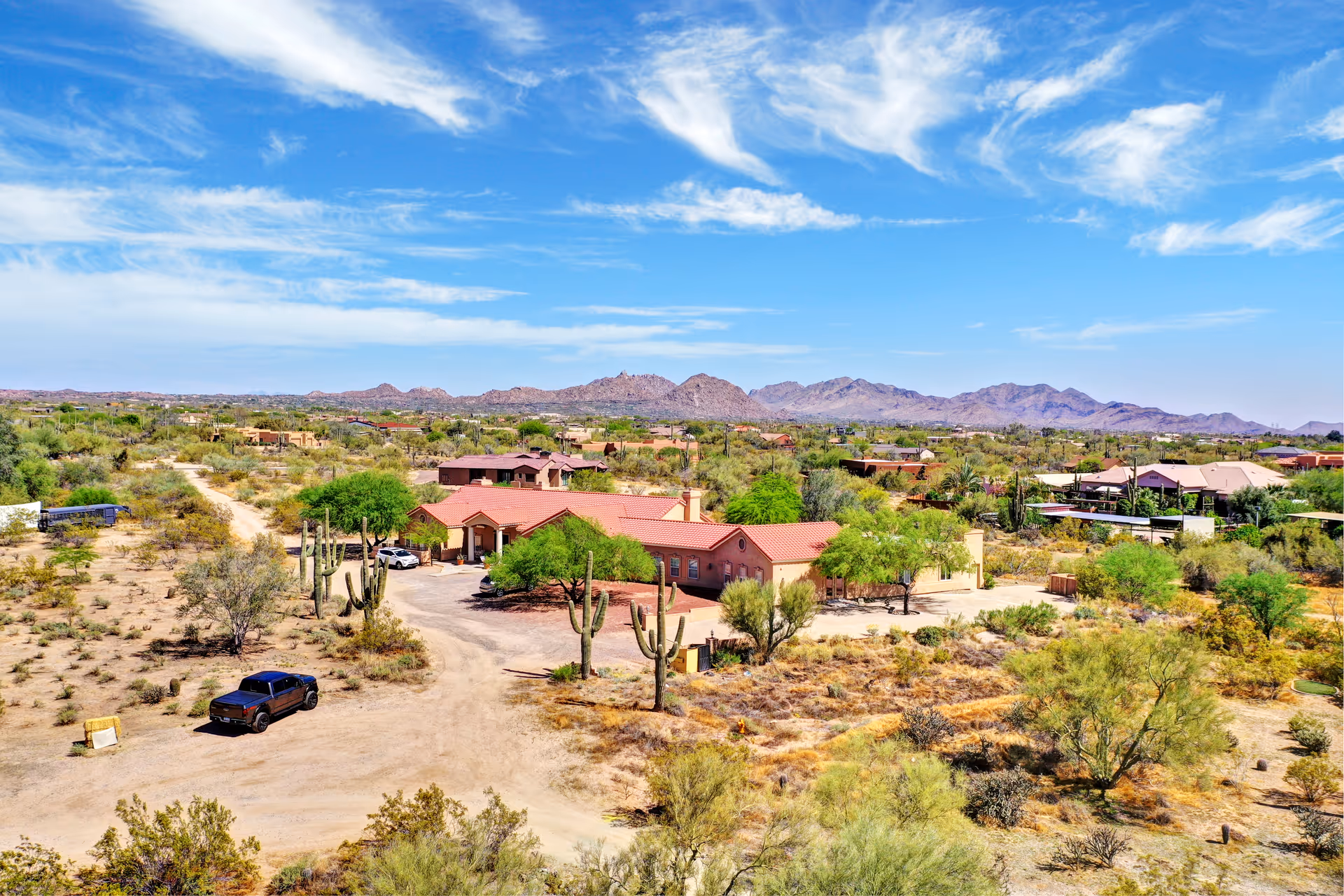 Desert senior living campus with red-roofed buildings and distant mountains.
