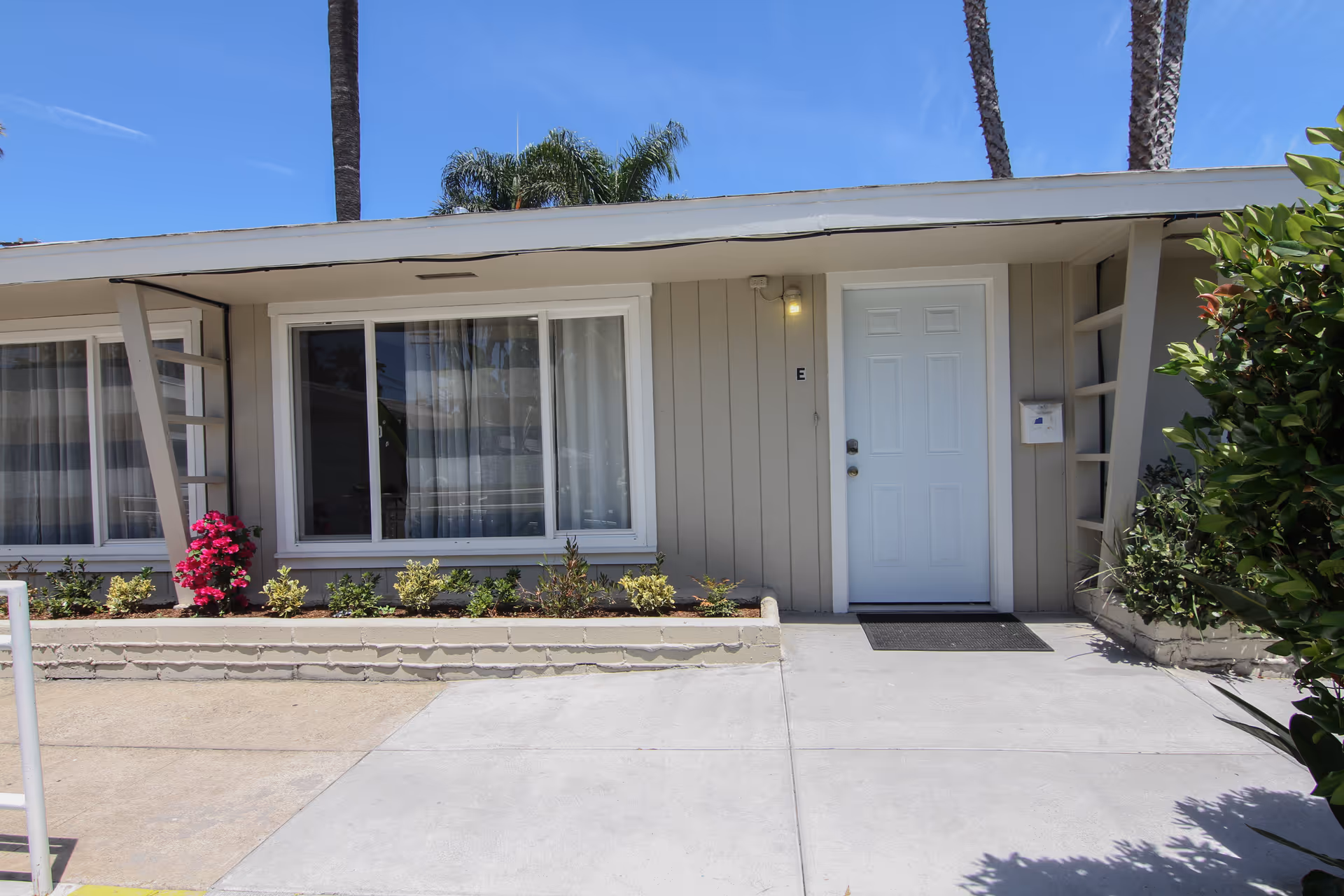 Front exterior of Mesaview Senior Assisted Living, showing a white door and large windows.