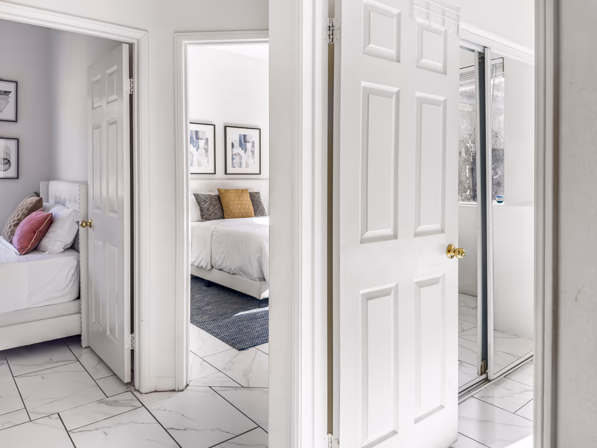 Open doors reveal a bright hallway leading to two neatly made bedrooms.