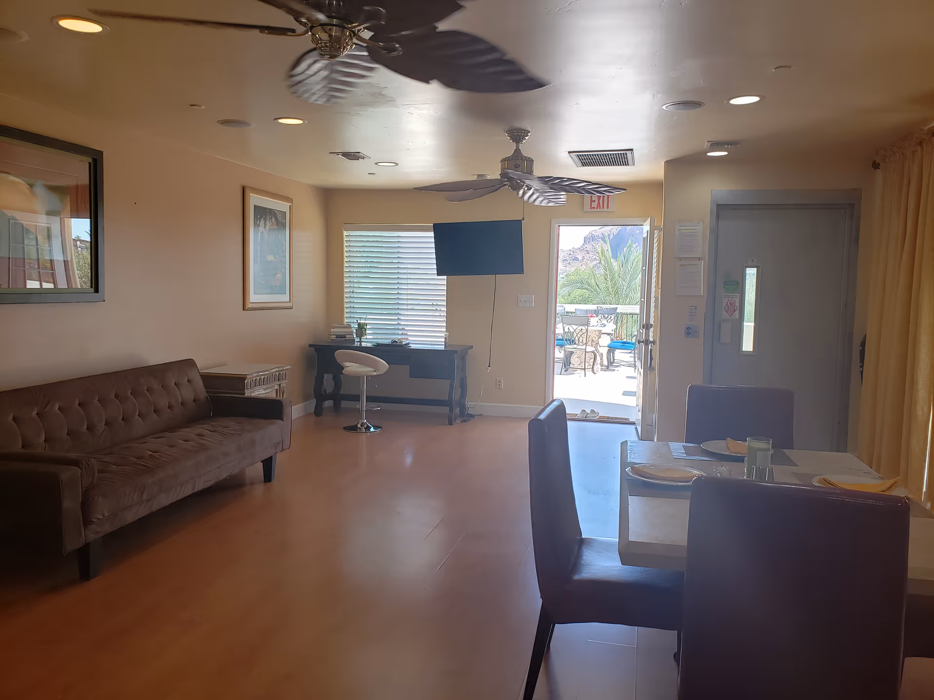 Interior common area with sofa, dining table, TV, and outdoor patio view