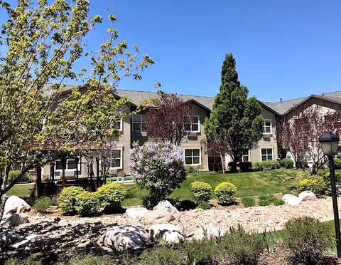 Two-story Avamere senior living building with landscaped front yard and rock garden.