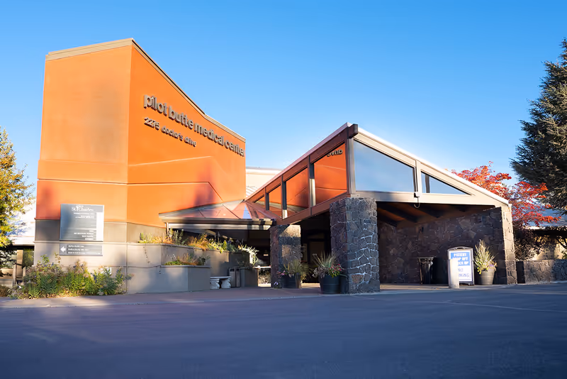 Front view of an orange-stone building entrance with a St. Charles Home Health Care sign.