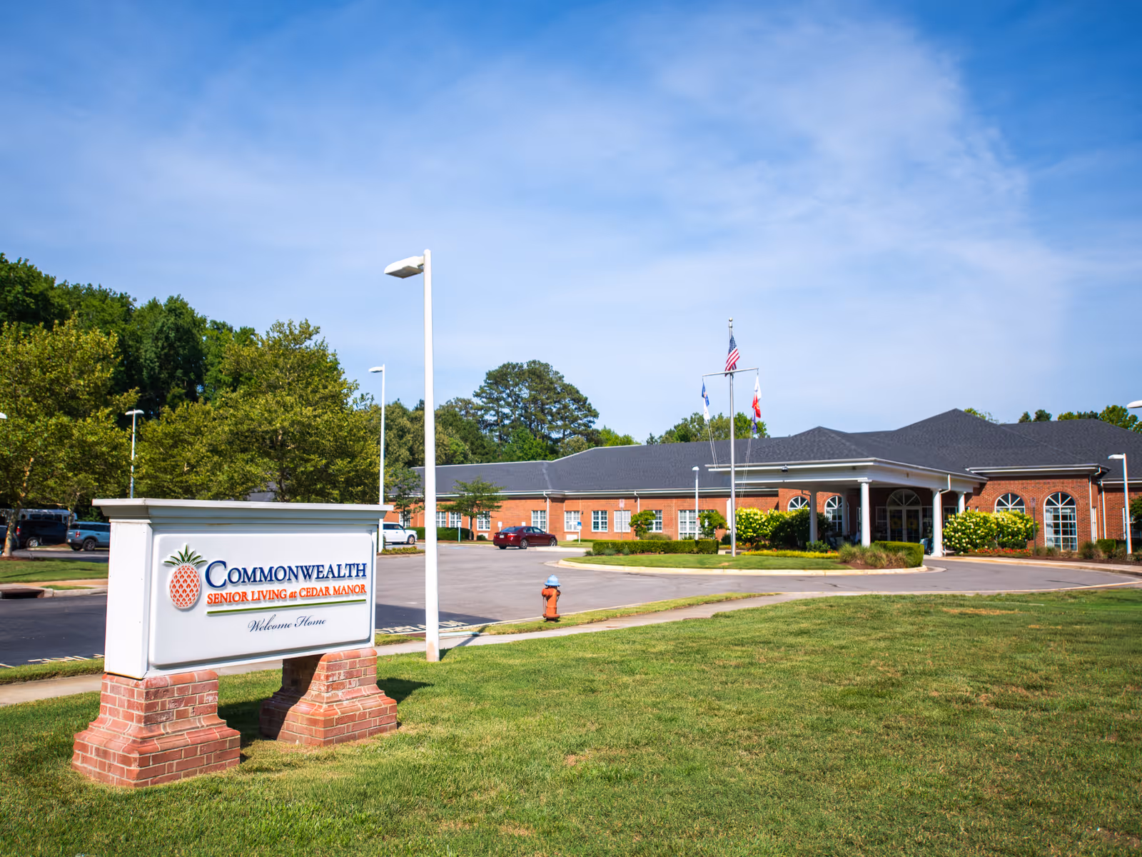 Exterior view of Commonwealth Senior Living at Cedar Manor with sign and brick building entrance.