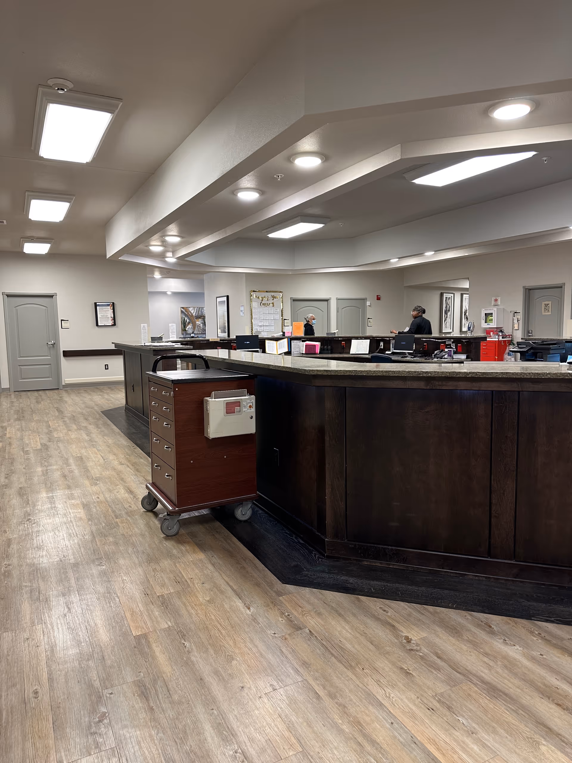Curved dark reception desk in a well-lit Cypress Creek facility lobby.