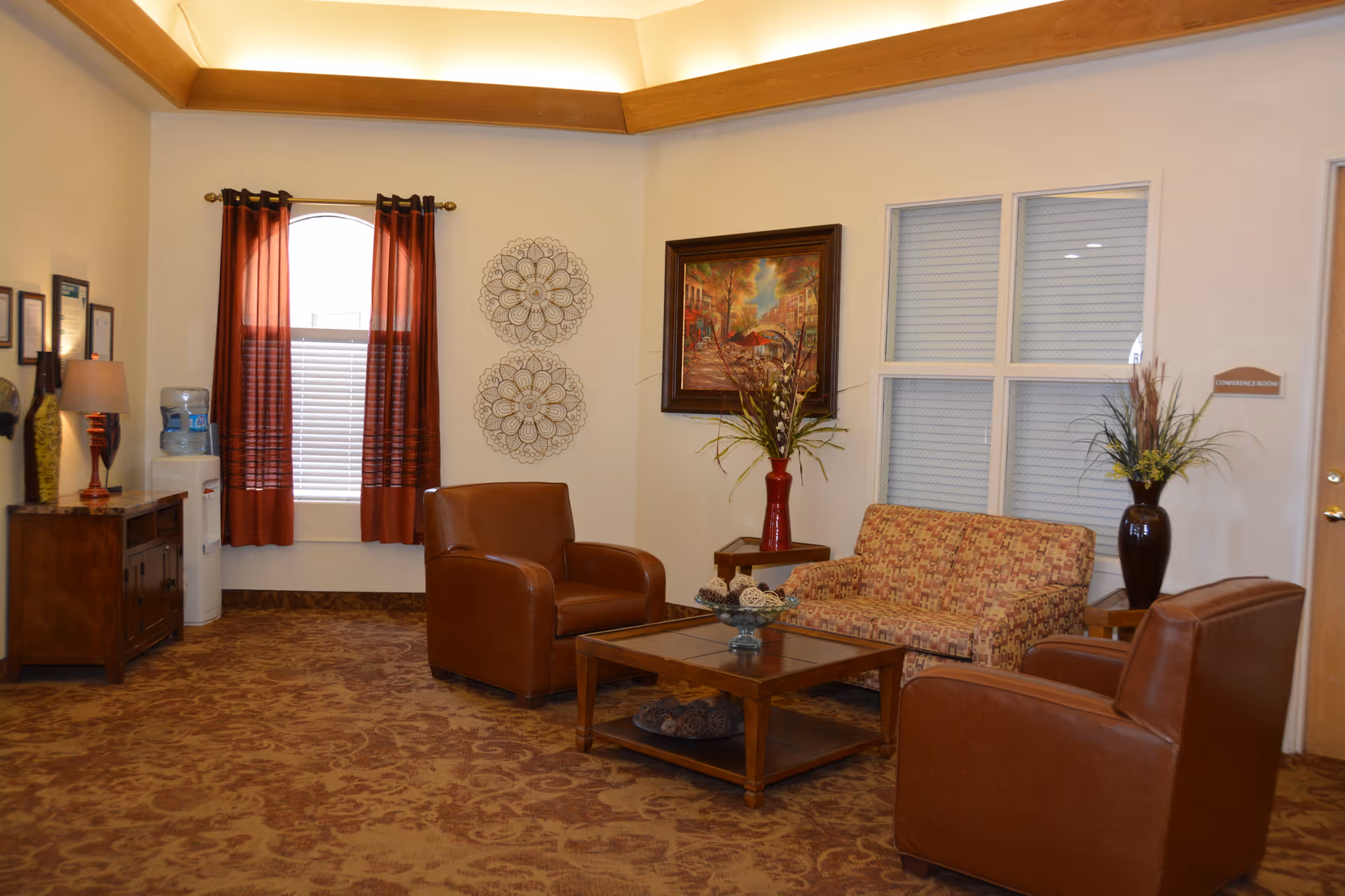 Cozy College Park Rehabilitation Center lounge with leather chairs, sofa, coffee table, and decor.