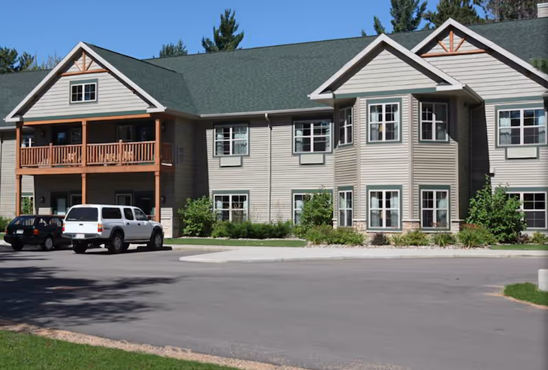 Exterior view of Milestone Senior Living Eagle River building with parked cars.